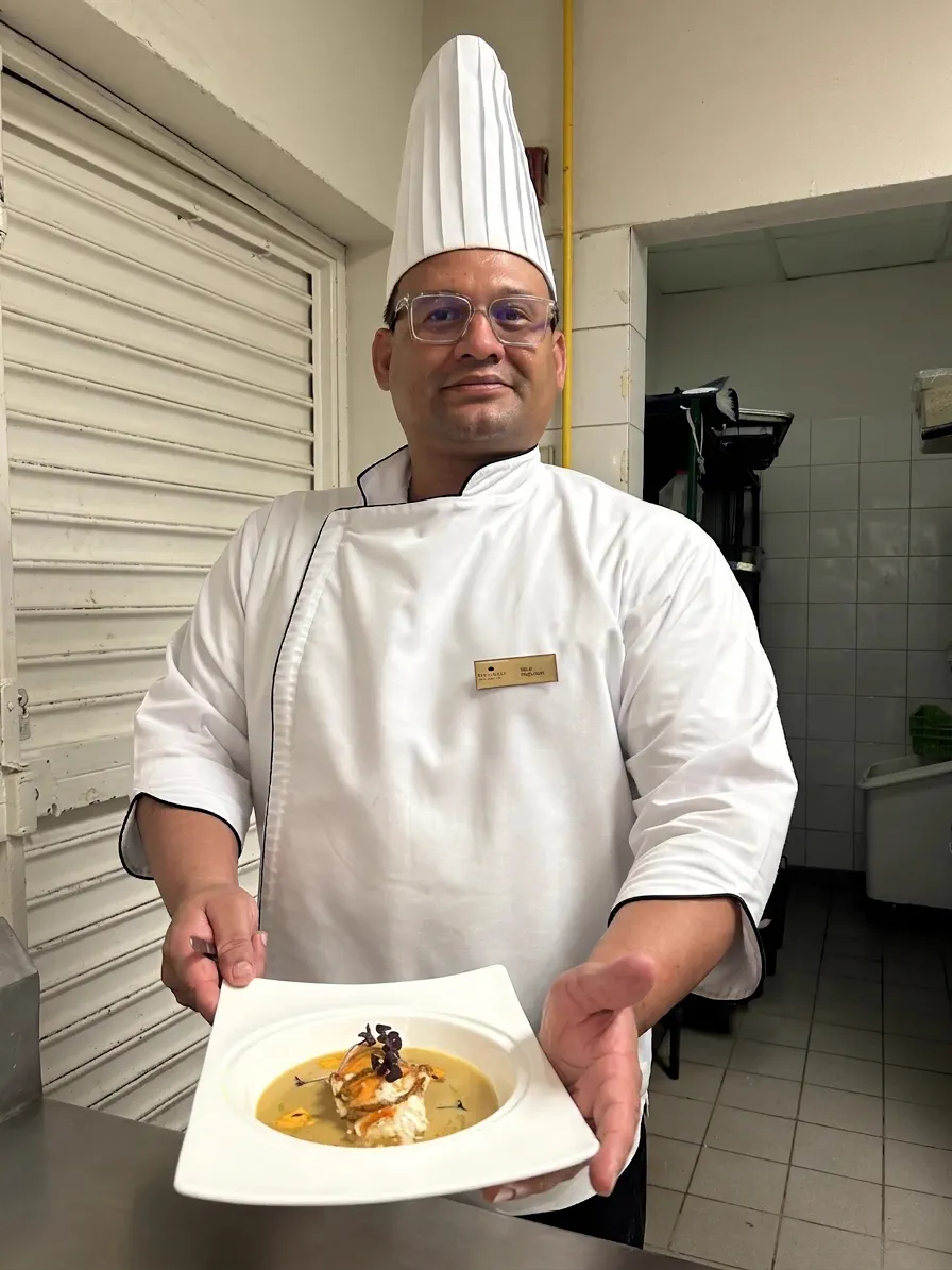 Chef José Félix Elizondo Peña en su cocina, presentando uno de sus platos