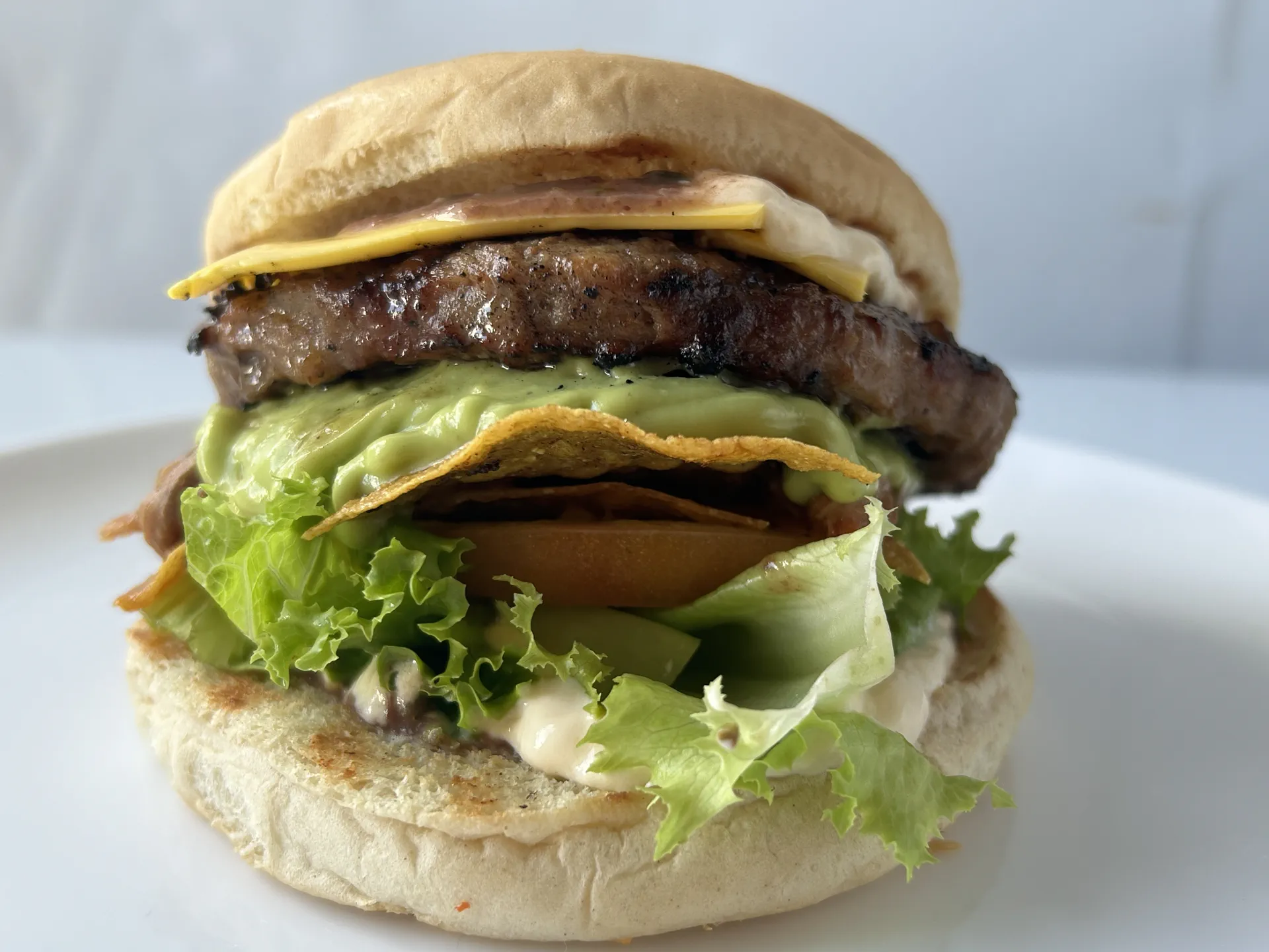 Hamburguesa a la brasa en pan brioche con queso y guacamole